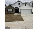 Modern two-story home featuring a mix of stone and siding, a two-car garage, and a well-manicured lawn at 11144 Cornerstone Way, Hampton, GA 30228