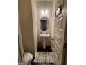 Small pedestal sink bathroom with neutral paint, wood floors and home decor at 6001 Nile Ct, Atlanta, GA 30349