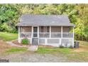 Inviting single-story home featuring a delightful screened porch with latticework and landscaped yard at 4481 Mclain Cir, Acworth, GA 30101