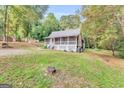 Scenic view of a quaint single-story home with a charming screened porch and verdant lawn at 4481 Mclain Cir, Acworth, GA 30101