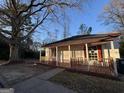 Charming home featuring a cozy front porch and freshly painted red and white trim, situated on a tree-lined lot at 18 Laurel St, Covington, GA 30014