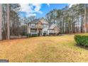 Charming two-story home with stone accents, covered porch, and spacious front yard at 65 Ashland Grove Ct, Sharpsburg, GA 30277