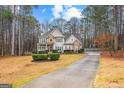 Charming two-story home with stone accents, covered porch, and long drive way at 65 Ashland Grove Ct, Sharpsburg, GA 30277