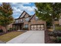 Charming brick home featuring a two-car garage, a well-maintained lawn, and colorful fall foliage at 5825 Trailwood Ct, Suwanee, GA 30024