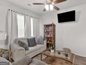 Comfortable living room featuring a love seat, large windows, and a ceiling fan at 340 Layfield Dr, Jonesboro, GA 30238