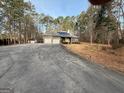 Brick home with an attached two-car garage, solar panels, and a large driveway at 5207 Sw West Shore Dr, Conyers, GA 30094