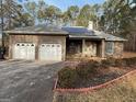 Brick home with an attached two-car garage, solar panels and well-maintained landscaping at 5207 Sw West Shore Dr, Conyers, GA 30094