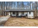 Exterior view of the home featuring a covered front porch with black railings and a paved driveway at 1436 Heritage Ct, Villa Rica, GA 30180
