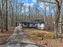 Single story home with long driveway, surrounded by forest and autumn leaves at 1436 Heritage Ct, Villa Rica, GA 30180