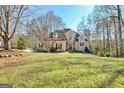 View of the inviting two-story home showcasing the lawn and mature trees in a landscaped front yard at 417 Plantain Ter, Peachtree City, GA 30269