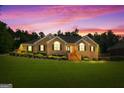 Lovely single-story brick home with a well-manicured lawn and landscaped front yard at sunset at 605 Clearwater Ct, Mcdonough, GA 30252