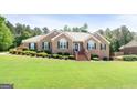 Beautifully landscaped front yard with brick stairs leading to the front door at 605 Clearwater Ct, Mcdonough, GA 30252