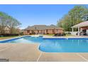 Backyard pool offers a relaxing escape with ample seating areas and well-maintained grounds at 605 Clearwater Ct, Mcdonough, GA 30252