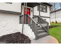 Inviting front entrance with gray stone stairs and a bright red front door, surrounded by landscaping at 7012 Winter Woods Ct, Morrow, GA 30260