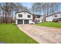 Suburban home featuring a two-car garage, manicured lawn, and a charming red front door at 7012 Winter Woods Ct, Morrow, GA 30260