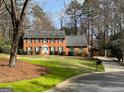 Charming two-story brick home featuring a manicured lawn and mature trees at 1121 Valley Ridge, Marietta, GA 30067