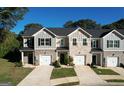 Beautiful townhome exteriors featuring a well-kept lawn, attached garages, and classic curb appeal at 142 Hampton Cir, Mcdonough, GA 30253