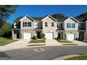 Inviting street view of townhomes with attached garages, beautiful exteriors and manicured lawns at 142 Hampton Cir, Mcdonough, GA 30253