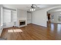 Open living room featuring hardwood floors, a fireplace with built-in shelves and an open archway at 10067 Freeman Ct, Jonesboro, GA 30236