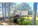 Large, grassy backyard with mature trees and a wooden fence, perfect for outdoor activities at 105 Windridge Dr, Fayetteville, GA 30215