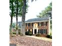 Beautiful two-story brick home with black shutters, dormer windows, and mature trees at 105 Windridge Dr, Fayetteville, GA 30215