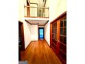Bright foyer features hardwood floors, an upper balcony, and a glimpse of the back of the home at 105 Windridge Dr, Fayetteville, GA 30215