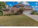Brick home with three car garage, set on a large well-manicured lawn with trimmed landscaping at 1500 Royce Dr, Locust Grove, GA 30248