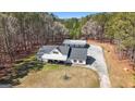 Aerial view of the property showcasing the home, garage, and wooded surroundings at 1185 Old Greenville Rd, Fayetteville, GA 30215