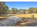 Gravel driveway leading to a secluded home surrounded by lush greenery and mature trees at 1185 Old Greenville Rd, Fayetteville, GA 30215