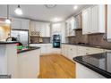Modern kitchen with white cabinets, stainless steel appliances, and a black granite countertop at 365 Falling Creek Bnd, Johns Creek, GA 30097