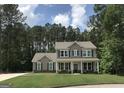 Charming two-story home with a well-manicured lawn and inviting front porch surrounded by lush trees at 85 Crabapple Ridge Dr, Oxford, GA 30054