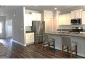Bright kitchen with white cabinets, stainless steel appliances, and a granite-topped island with bar stools at 85 Crabapple Ridge Dr, Oxford, GA 30054