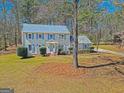 Beautiful two-story home featuring light-grey siding, blue shutters, and mature trees at 175 Ashley Dr, Fayetteville, GA 30214