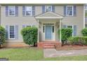 A close-up of a home's blue front door, flanked by meticulously trimmed hedges and decorative lighting at 175 Ashley Dr, Fayetteville, GA 30214
