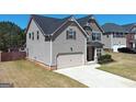 A view of the house and driveway featuring an attached two-car garage and manicured lawn at 7019 Diamond Dr, Rex, GA 30273