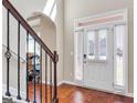 Bright foyer featuring hardwood floors, staircase with decorative iron railings, and a white front door with sidelights at 7019 Diamond Dr, Rex, GA 30273