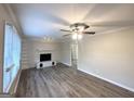 Bright living room featuring a decorative fireplace, hardwood floors, and a ceiling fan at 20 Maddox Dr, Locust Grove, GA 30248