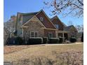 Two-story home with stone accents and a well-manicured lawn, showcasing its charming curb appeal at 108 Caraway Rd, Locust Grove, GA 30248