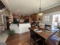 Open-concept kitchen featuring a spacious island, stainless steel appliances, and a dining area with hardwood floors at 108 Caraway Rd, Locust Grove, GA 30248