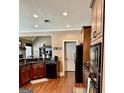 Modern kitchen featuring dark wood cabinetry, granite countertops, and stainless steel appliances with ample counter space at 108 Caraway Rd, Locust Grove, GA 30248