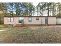 Rear view of a cozy home featuring a sliding glass door and a small wooden porch with a ladder at 105 Woodfield Rd, Covington, GA 30014