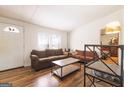 Cozy living room with hardwood floors, neutral walls, two windows, and a view of an inviting front entrance at 105 Woodfield Rd, Covington, GA 30014
