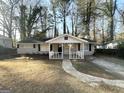 Single-story home featuring a covered front porch, neutral exterior paint, and manicured landscaping at 3395 Longleaf Dr, Decatur, GA 30032