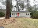 Cozy home with a gray exterior, red front door and tree covered yard at 2000 Marvin Sw Ln, Atlanta, GA 30311