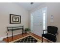 Bright foyer features wood floors, a glass console table, and classic black accents at 4030 Cresent Walk Ne Ln, Suwanee, GA 30024