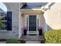 Inviting front porch with black front door, potted plants and stylish welcome mat at 4030 Cresent Walk Ne Ln, Suwanee, GA 30024