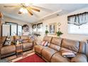 Spacious living room with plush leather seating, ceiling fan, and cozy decor at 9100 Settlers Grove Ne Rd, Covington, GA 30014