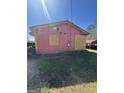 Damaged side of pink ranch home with boarded windows, yellow trim, and green grass at 329 Oak Dr, Social Circle, GA 30025