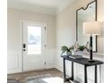 A welcoming entryway with a console table, lamp, and large mirror reflecting natural light at 10453 Trellis Lane (Lot 28), Hampton, GA 30228