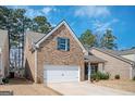 Brick two-story home showcasing a two-car garage and well-maintained landscaping at 220 Long Dr, Mcdonough, GA 30253